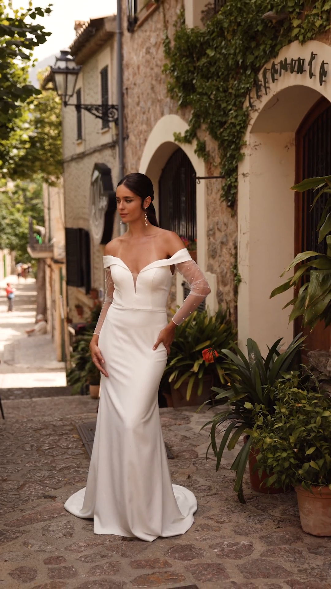 Bride Wearing Crepe Mermaid Wedding Dress Style AQUA With Folded Neckline And Detachable Pearl Sleeves Bride Wearing Crepe Mermaid Wedding Dress Style AQUA With Folded Neckline And Detachable Pearl Sleeves