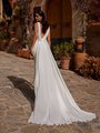 Back view of bride in ivory crepe wedding dress with chiffon pleated detail along v-neckline and chapel chiffon train Back view of bride in ivory crepe wedding dress with chiffon pleated detail along v-neckline and chapel chiffon train
